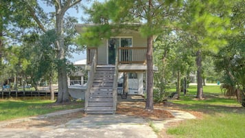 A two-story house with a wooden staircase leading to a balcony.