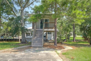 A two-story house with a wooden staircase leading to a balcony. - 4 Mi to Beach! Canal-front Escape in Bay St Louis (Bay St Louis)