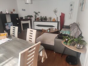 A modern living room with a dining area, a TV, and various decorative items including plants and artwork. - Charming house in the heart of Eymoutiers (Eymoutiers)