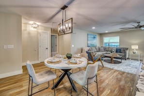 A dining area with a round table, four chairs, and a chandelier. - Boat Dock & Game Room! Lake Hamilton Home (Hot Springs)