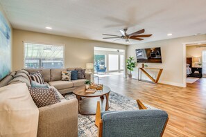 A spacious living room with a sofa set, a coffee table, and a television mounted on the wall. - Boat Dock & Game Room! Lake Hamilton Home (Hot Springs)