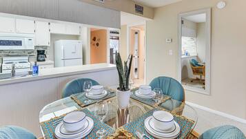 A modern kitchen with white cabinets, a refrigerator, and a coffee maker.