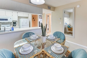 A modern kitchen with white cabinets, a refrigerator, and a coffee maker. - Lake Okeechobee Condo w/ Pool & Patio! (Clewiston)