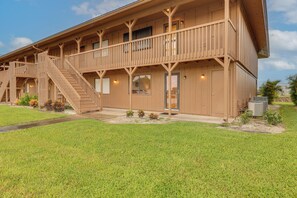 A two-story wooden building with a balcony, a staircase, and a door.