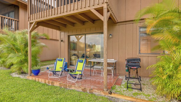 Un patio couvert comprenant deux chaises de jardin, une table et un barbecue.