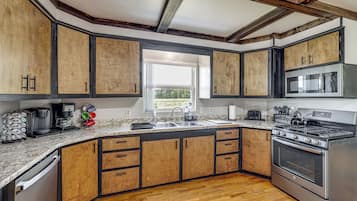 A modern kitchen with wooden cabinets, a stainless steel stove, and a built-in microwave.