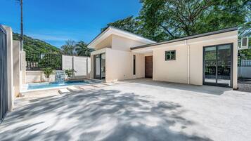 Una casa moderna con piscina, ventanas amplias y techo plano.
