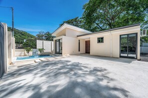 A modern house with a swimming pool, large windows, and a flat roof.