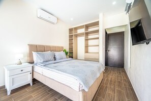 A modern bedroom with a bed, nightstand, and built-in wardrobe.
