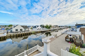 A waterfront property with a dock, a row of houses, and a clear sky.