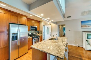 A modern kitchen with stainless steel appliances, a granite countertop, and wooden cabinets. - Dock & Hot Tub! Family Escape, 6 Mi to LBI Beaches (Manahawkin)