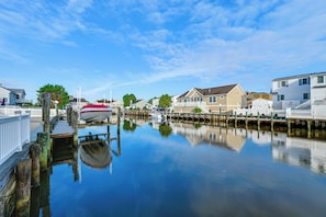 A waterfront property with a dock, calm water, and residential buildings.