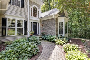 A two-story house with a brick exterior and a stone facade. - Walk to Herrington Harbor: Spacious Bay Home (Tracys Landing)