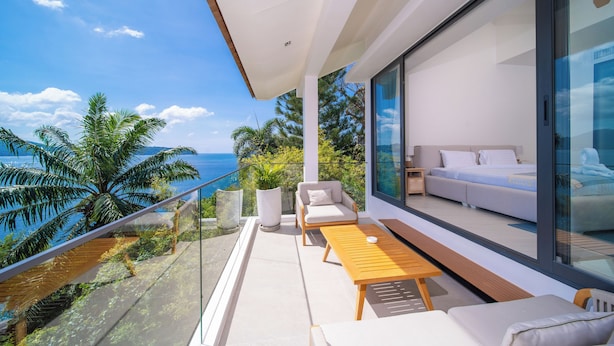 A modern balcony with a sofa, a table, and a view of the ocean. - Villa SARA (Kathu)
