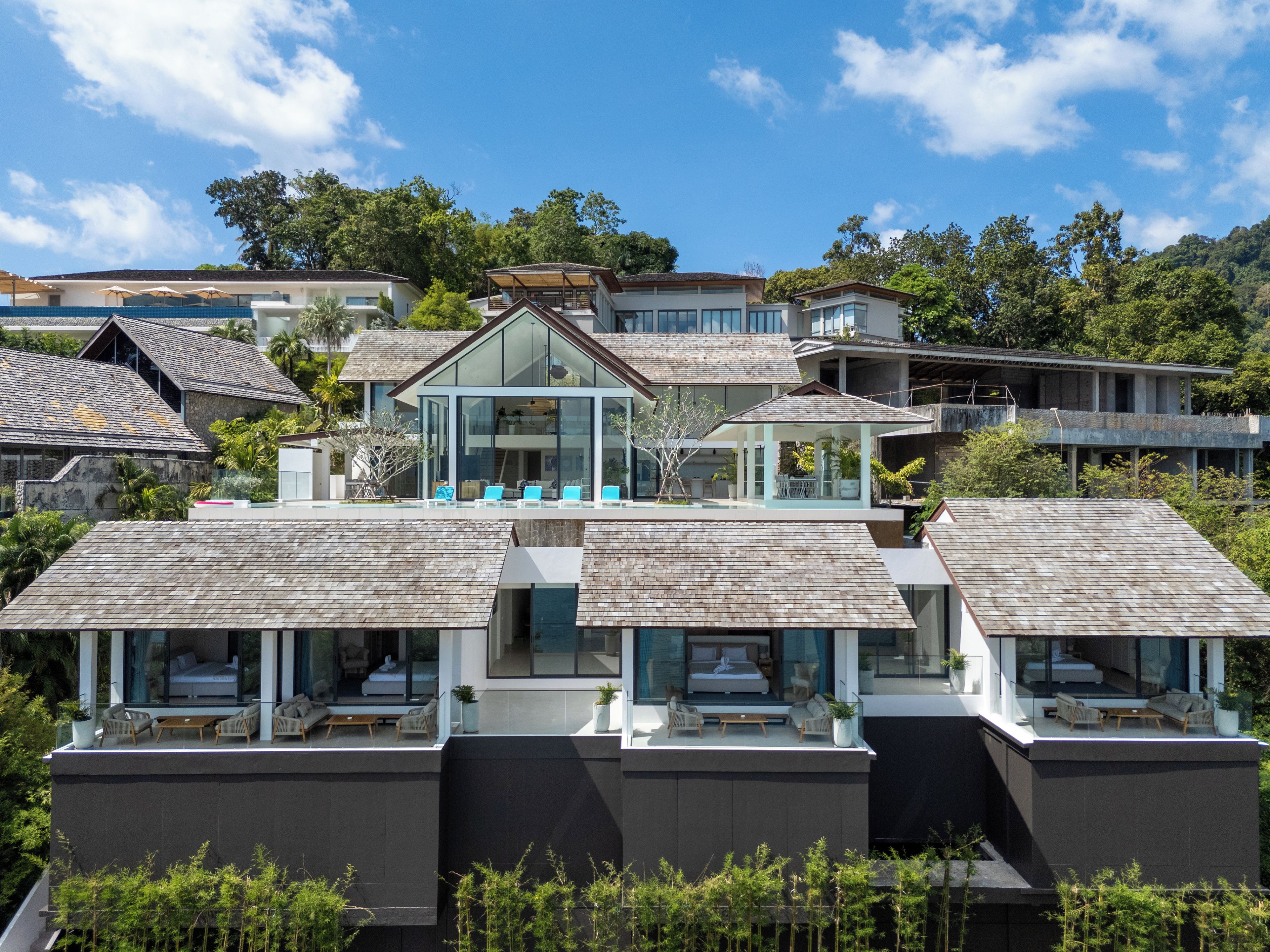 Un edificio residencial moderno con varios balcones, ventanas amplias y vistas despejadas del entorno verde.