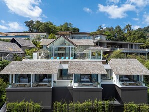 Un edificio residencial moderno con varios balcones, ventanas amplias y vistas despejadas del entorno verde.