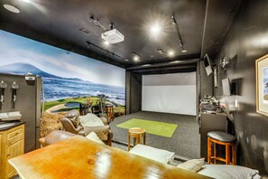 A home theater room with a large screen, seating area, and a projector.