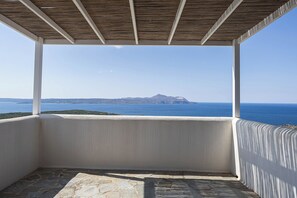 An empty balcony with a view of the sea and a distant island. - Villa Akrotini with Sea view and Hot Tub (Kokkino Chorio)