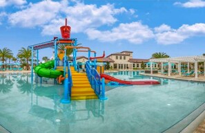A water park with a multi-level play structure, a pool, and lounge areas. - Spacious 6 Bedroom Disney Themed at Windsor Resort. 15 Minutes to the parks! (Kissimmee)