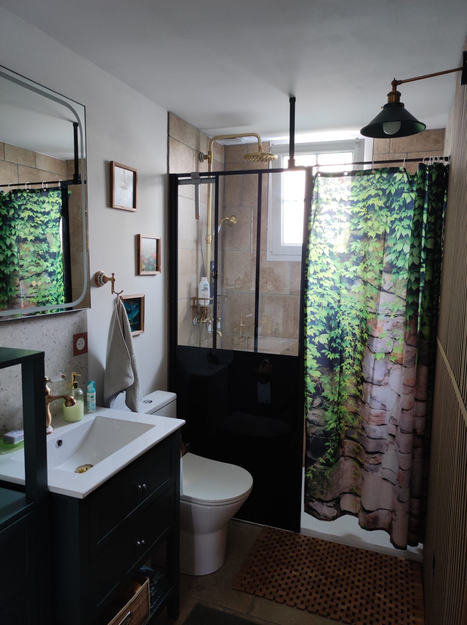Et badeværelse med håndvask, toilet og bruseområde.