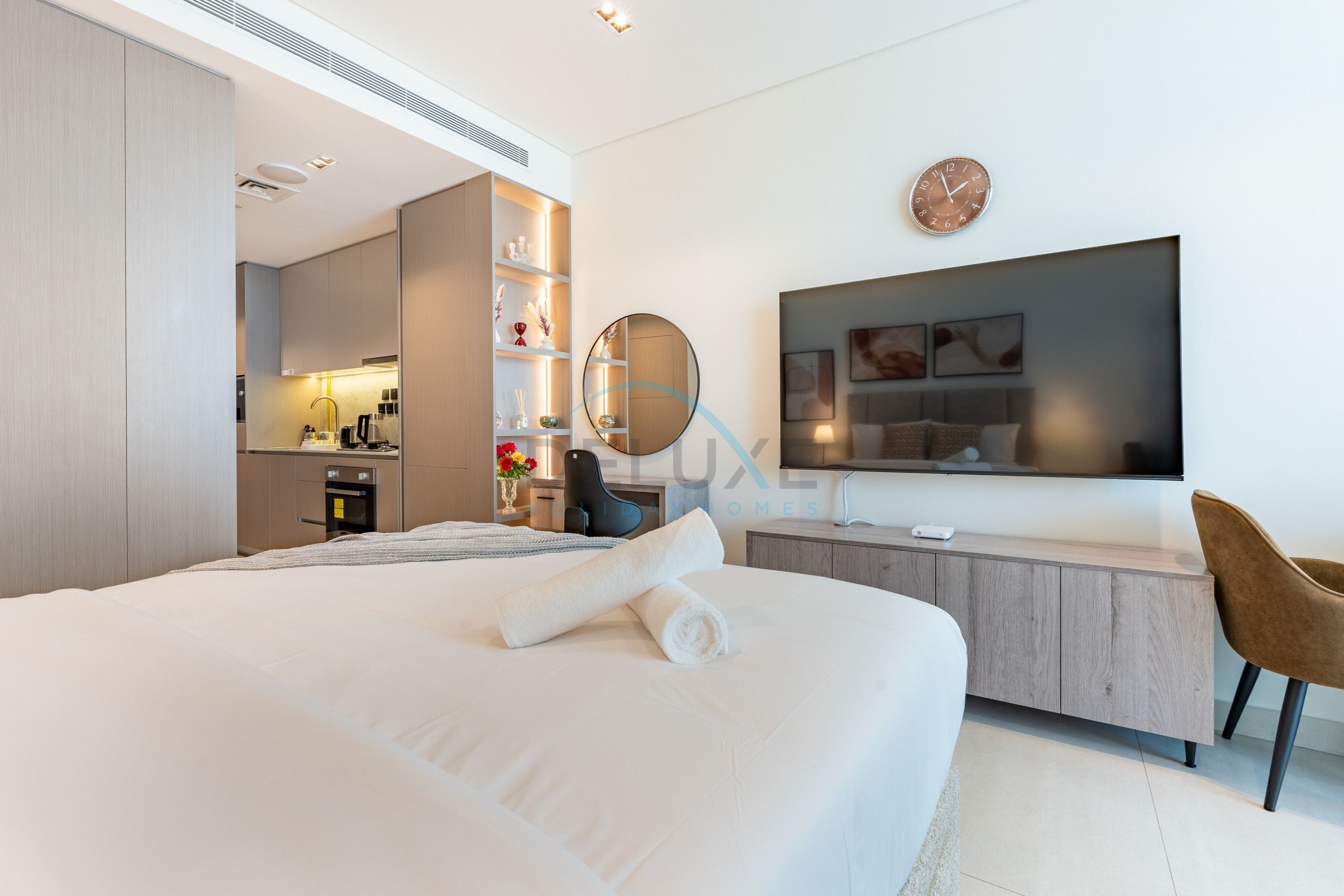 Une chambre d’hôtel moderne équipée d’un grand lit, d’un bureau, d’une télévision et d’une salle de bain.