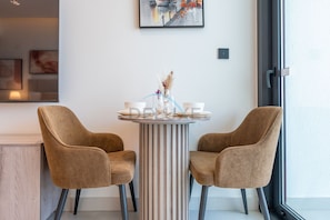 Ein modernes Interieur mit einem runden Tisch, zwei Stühlen und einer Vase mit Blumen.