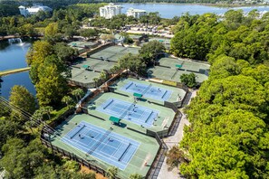 An aerial view of a tennis facility with multiple courts surrounded by dense greenery and a body of water in the background. - NEW Listing*Book 3 Nights Get 1 Free/See Description*Golf Cart*Beach/Pool Access (Miramar Beach)