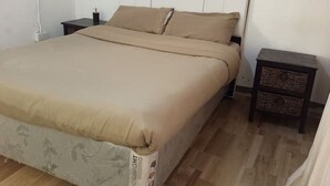 Ein Schlafzimmer mit einem Bett, einem Nachttisch und einem Beistelltisch.