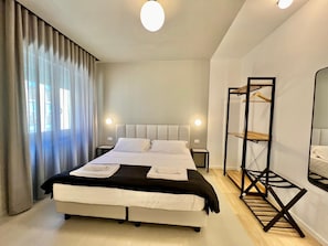 A modern hotel room with a large bed, bedside tables, a wardrobe, and a mirror. - Luciano Queen's Guest House (Rome)