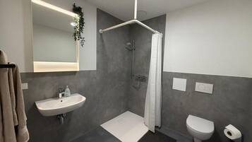 Ein modernes Badezimmer mit Dusche, Toilette und Waschbecken.
