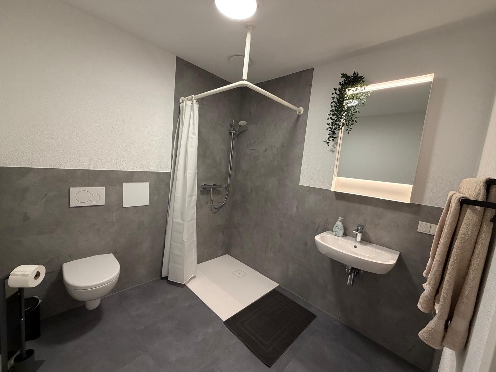Ein modernes Badezimmer mit Dusche, Toilette und Waschbecken.