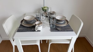 Uma mesa de jantar posta com pratos, tigelas, copos e talheres.