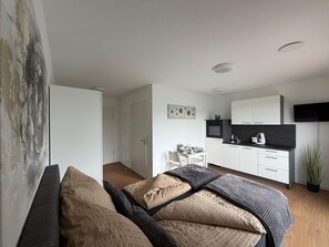 Ein modernes Schlafzimmer mit einem Bett, einem Nachttisch und einem Beistelltisch.