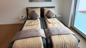 A modern bedroom with a large bed, a painting on the wall, and a window. - Apartment in A Hotel 'Werner Apartments Mecklar 9' with Shared Terrace, Shared Garden and Wi-Fi (Ludwigsau)