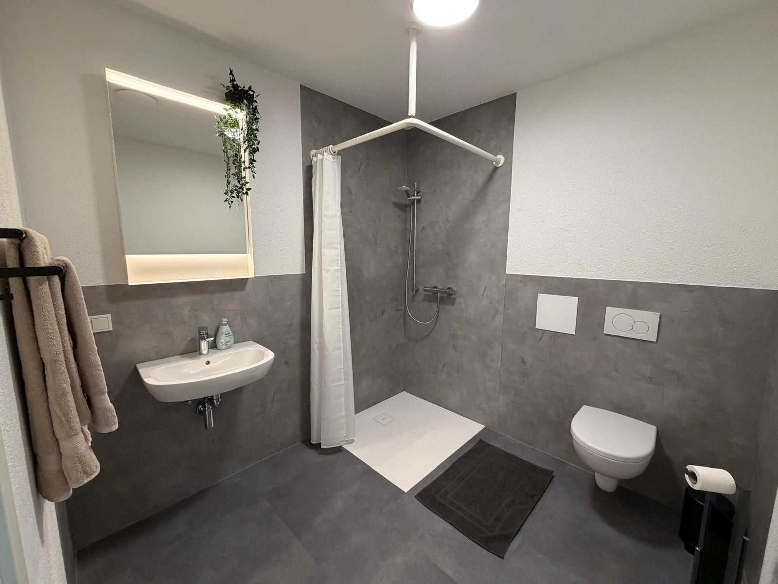 Un bagno moderno con doccia, wc e lavandino.