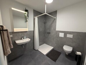 Ein modernes Badezimmer mit Dusche, Toilette und Waschbecken.