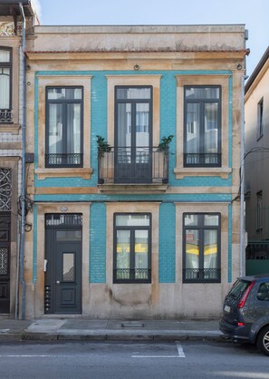 A two-story building with a flat facade, large windows, and a small balcony. - Sweet Escape | Charming One-Bedroom Apartment in the Heart of Porto (Porto)