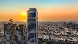 A cityscape with modern high-rise buildings, a clear sky, and a sunset. - Luxury Skyline 2BR with Infinity Pool (Dubai)