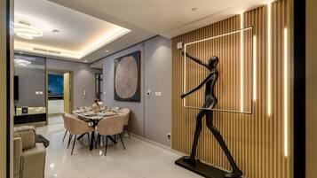 A modern interior with a dining area, a large abstract painting, and a unique wall sculpture.