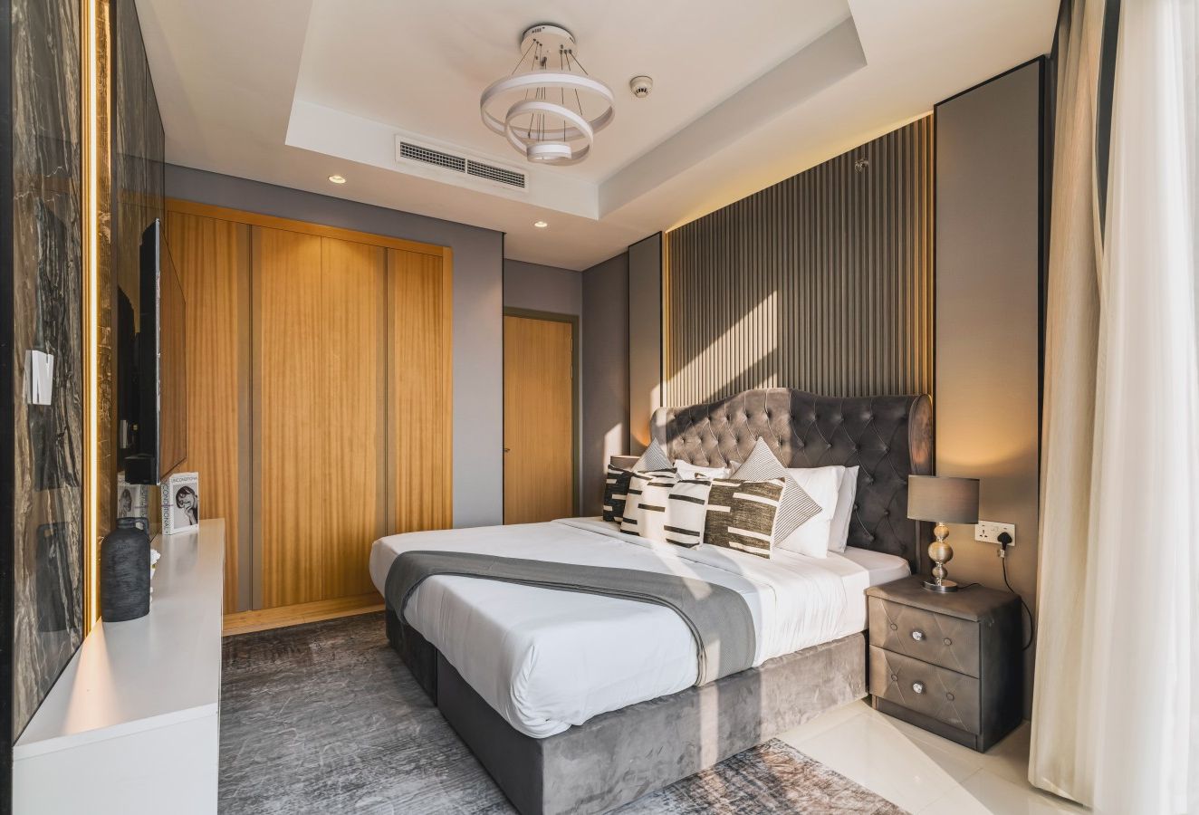 Bedroom featuring a comfortable bed, bedside tables with drawers, decorative plants, and elegant décor, creating a cozy and relaxing atmosphere.