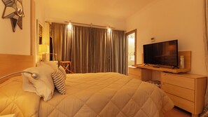 A hotel room with a bed, a television, a desk, and a chair. - Semi-detached villa in a luxury hotel resort · El Rodat, Jávea (VC)