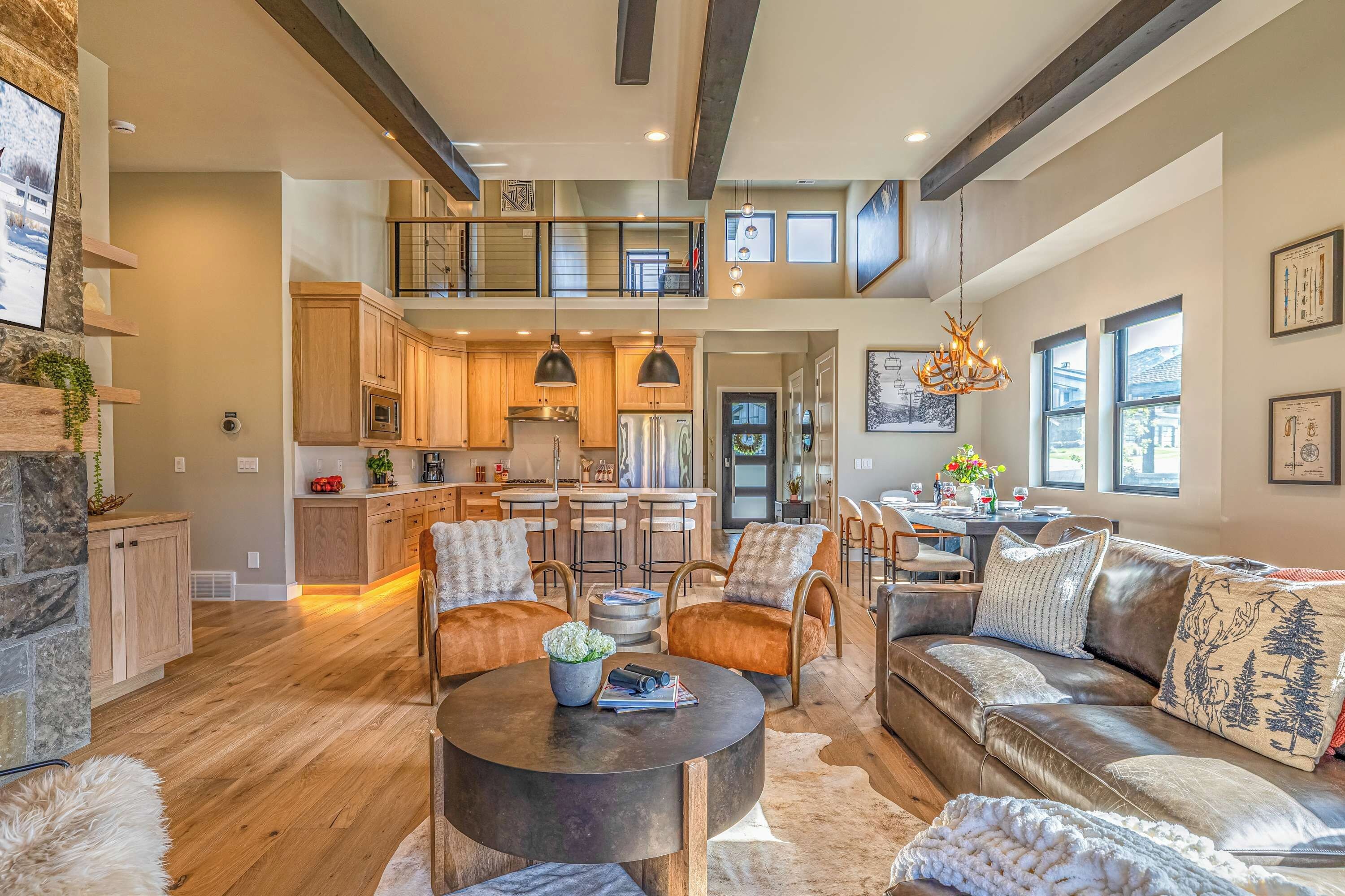 A spacious living area with a high ceiling, a dining area, and a kitchen with modern appliances.