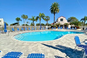 A swimming pool with blue chairs and palm trees. - Ground Floor | Resort Amenities | Minutes to Beaches | Vista Verde East 105 (Saint Petersburg)