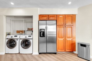 A laundry area with two washing machines and a stainless steel refrigerator. - Ground Floor | Resort Amenities | Minutes to Beaches | Vista Verde East 105 (Saint Petersburg)