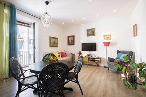 A modern living room with a dining area, a flat-screen TV, and artwork on the walls. - Casa Mirea – Downtown Sorrento, Between the Cathedral and Marina Piccola (Sorrento)