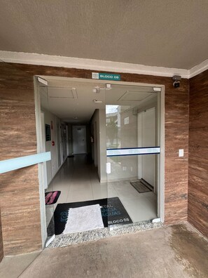Un couloir avec une porte en verre portant l’inscription « Bloco 08 », qui donne accès à une pièce.