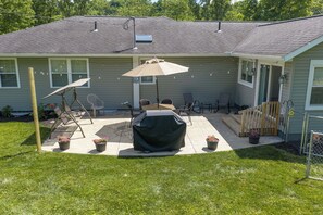 A residential backyard with a covered grill, patio furniture, and a small deck. - 4-BR home, custom kitchen, rec room, patio, grill. Near hiking & Amish country! (Dover)