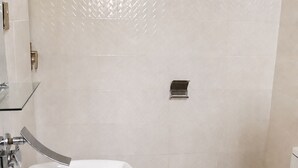 Casa de banho com lavatório branco, sanita e zona de duche.