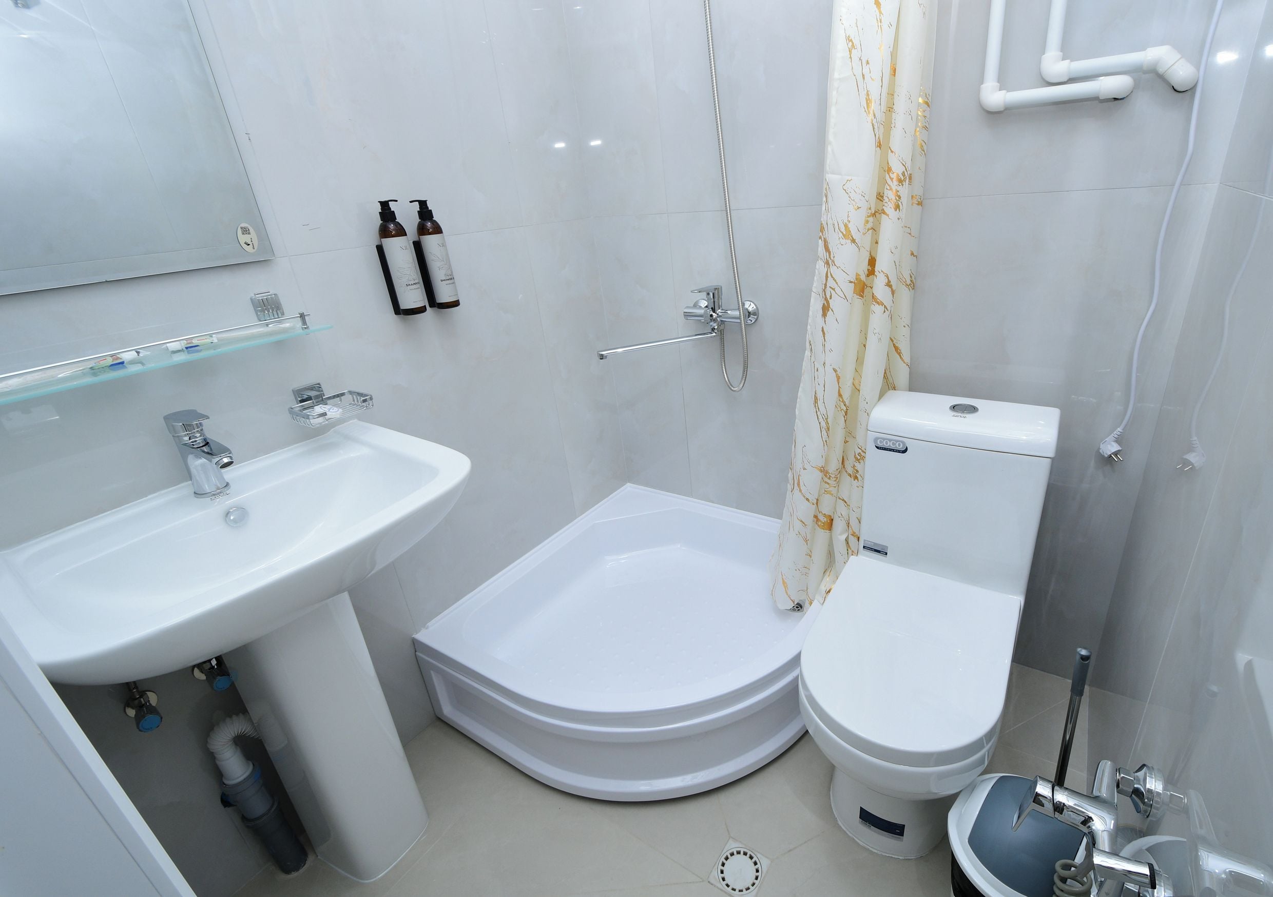 A modern bathroom with a white sink, a bathtub, and a toilet.