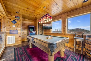 A wooden interior with a pool table, a bar stool, and a mounted television. - Thunder Bear Ridge 3 Bedroom Cabin (Sevierville)